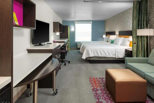 佩吉Home2 Suites By Hilton Page Lake Powell的配有一张床和一张书桌的酒店客房
