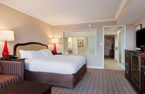 尼亚加拉瀑布希尔顿尼亚加拉大瀑布/瀑布景观套房酒店的酒店客房设有一张大床和一张沙发。