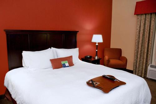 拉斯维加斯拉斯维加斯/北赛道汉普顿酒店的一间酒店客房,配有一张床铺,上面装有棕色的托盘