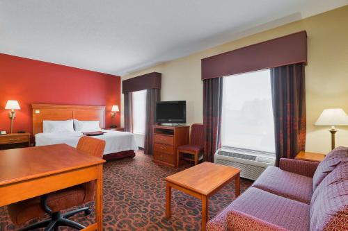 马里恩马里恩汉普顿酒店的酒店客房配有一张床、一张沙发和一张书桌。