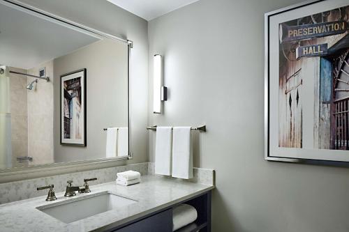 肯纳新奥尔良机场希尔顿酒店的一间带水槽和大镜子的浴室