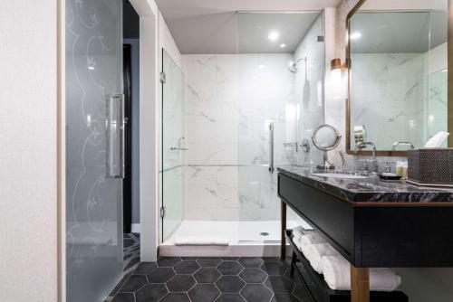 芝加哥芝加哥希尔顿伦敦之家古玩系列酒店的一间带玻璃淋浴和水槽的浴室