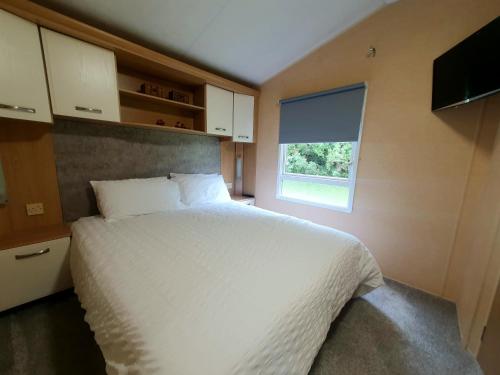 SwarlandBadger Retreat的卧室配有白色的床和窗户。