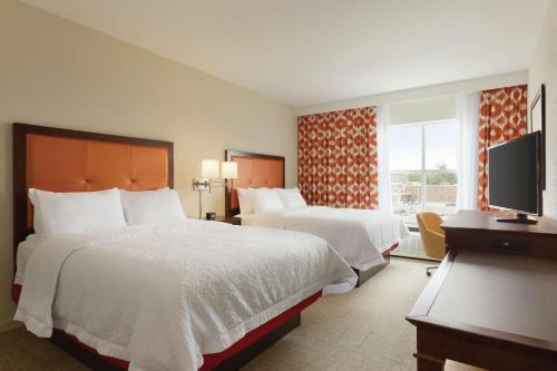 圣奥尔本斯Hampton Inn, St. Albans Vt的酒店客房设有两张床和电视。