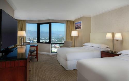 洛杉矶洛杉矶环球影城希尔顿酒店的酒店客房设有两张床和一台平面电视。