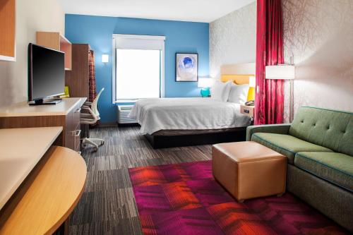 查尔斯湖Home2 Suites By Hilton Lake Charles的酒店客房,配有床和沙发