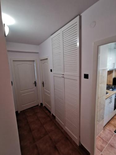 大盐矿镇Apartament Ocnele Mari的走廊设有白色壁橱门和厨房