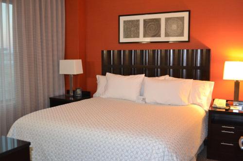 帕姆代尔棕榈希尔顿合博套房酒店的一间卧室配有一张带橙色墙壁的大床