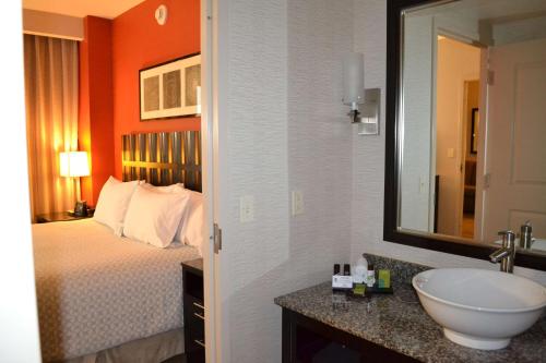 帕姆代尔棕榈希尔顿合博套房酒店的浴室设有床、水槽和镜子