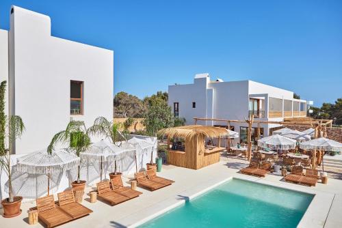 埃斯普霍斯Mar Suites Formentera by Universal Beach Hotels的一个带游泳池和椅子的度假胜地和一座建筑