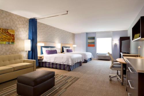 哈斯布鲁克高地哈斯布鲁克高地希尔顿欣庭套房酒店的大型酒店客房,配有一张床和一张书桌