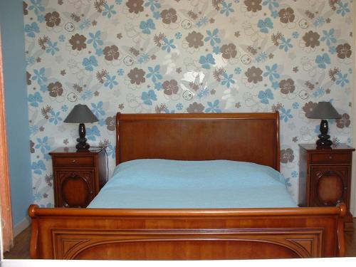 绍维尼多特贝尔夫旅馆的一间卧室配有木床和2个床头柜
