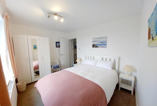 瑟勒斯通9 The Downs, Thurlestone, South Devon on the coastal footpath overlooking Burgh Island的一间卧室配有一张带红白毯子的床