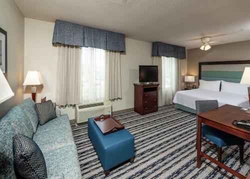 斯卡伯勒波特兰希尔顿惠庭套房酒店的酒店客房配有一张床、一张沙发和一张书桌。
