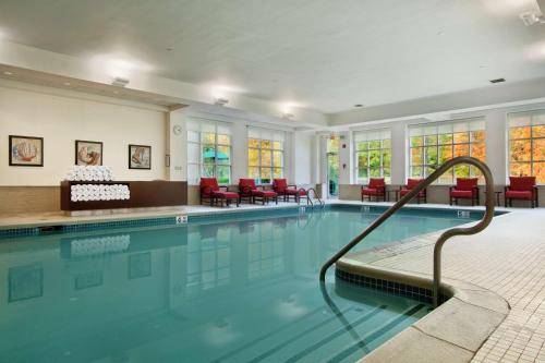 Pearl River珍珠河希尔顿酒店的一座带红色椅子的建筑中的游泳池