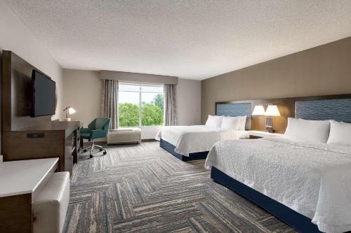 Fruitland弗鲁特兰汉普顿套房酒店的酒店客房设有两张床和一台平面电视。