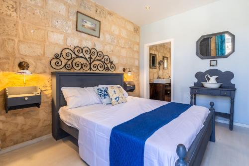 瓦莱塔Valletta Bastions Seafront House的一间卧室配有一张带蓝白色毯子的床