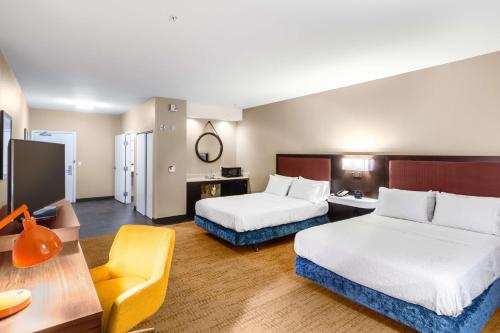 拉勒米拉勒米希尔顿恒庭酒店的酒店客房,配有两张床和椅子
