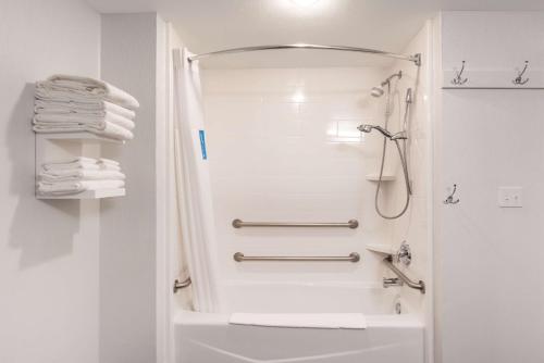拉勒米拉勒米希尔顿恒庭酒店的带淋浴和盥洗盆的白色浴室