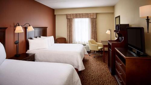 北湾诺斯贝希尔顿汉普顿酒店的酒店客房设有两张床和一台平面电视。