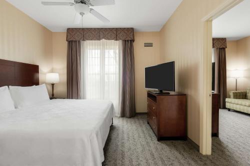 萨克拉门托萨克拉门托机场纳托马斯希尔顿惠庭套房酒店的配有一张床和一台平面电视的酒店客房