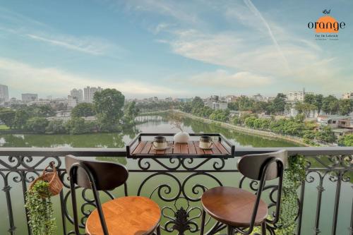 河内iRest Orange Tay Ho Lakeside Apartment的阳台配有椅子,享有河景