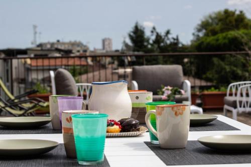 马格拉[Terrazza privata] Venezia Mestre的桌子上放着杯子和盘子