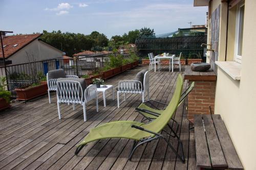 马格拉[Terrazza privata] Venezia Mestre的阳台的甲板上配有椅子和桌子