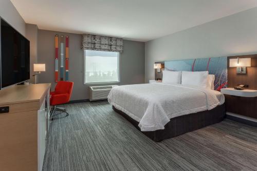 奥克兰Hampton Inn Oakland Downtown-City Center的配有一张床和一台平面电视的酒店客房