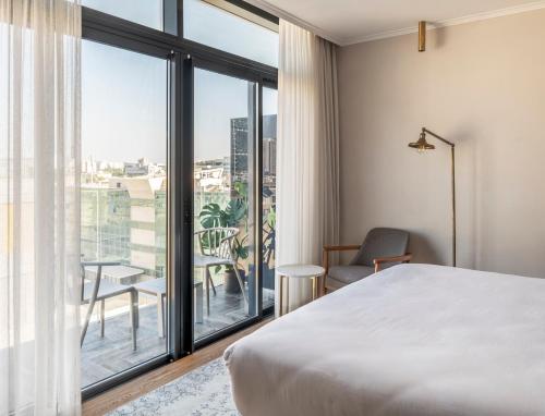 特拉维夫Jo Shtibel Tel-Aviv的一间卧室设有一张床和一个大窗户