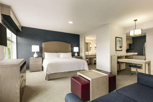 伍斯特Homewood Suites By Hilton Worcester的配有一张床和一张书桌的酒店客房
