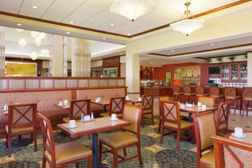 什里夫波特什里夫波特希尔顿花园酒店的一间带桌椅的餐厅和一间酒吧