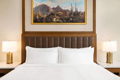 斯科茨Hilton North Scottsdale At Cavasson的一间卧室配有一张大床和两盏灯