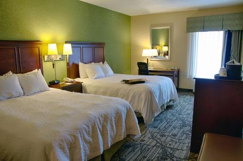 胡伯高地德顿/胡伯高地汉普顿酒店的酒店客房设有两张床和窗户。