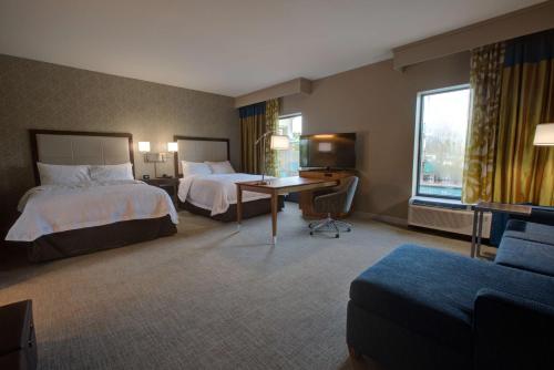 坦帕希尔顿坦帕布什花园区汉普顿酒店及套房的酒店客房配有两张床和一张书桌