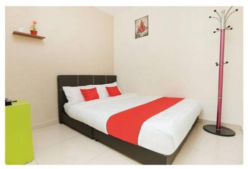 小笨珍Semerah Suites Homestay的一间卧室配有一张带红白毯子的床