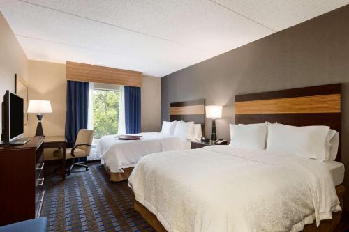 坎普泉温泉露营汉普顿酒店及套房的酒店客房设有两张床和电视。