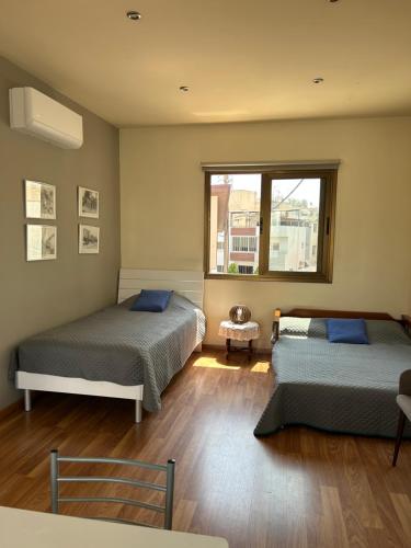 拉纳卡Extremely comfy 10min walk to Beach & Town的一间卧室设有两张床和窗户。