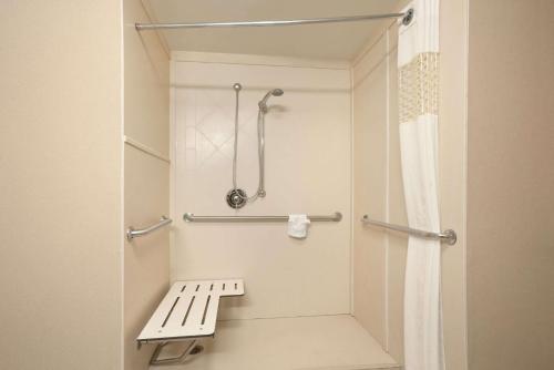谢里登谢里登汉普顿酒店的一间带长凳和淋浴的浴室