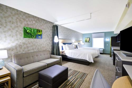 莫米Home2 Suites By Hilton Maumee Toledo的酒店客房,配有床和沙发