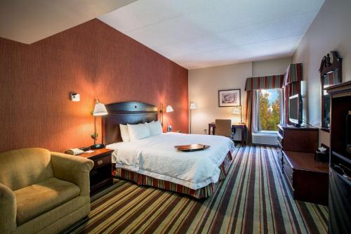 斯特布里奇斯特布里奇希尔顿恒庭酒店的配有一张床和一把椅子的酒店客房