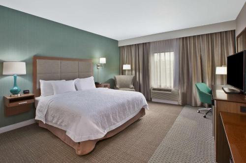 AllianceHampton Inn & Suites Alliance的酒店客房,配有床和电视
