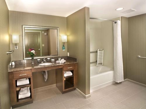 米德尔敦纽波特米德尔敦希尔顿霍姆伍德套房酒店的一间带水槽、浴缸和镜子的浴室