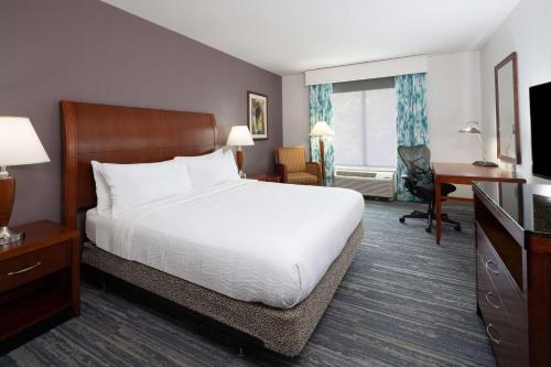 格罗顿迈斯狄克/格罗顿希尔顿花园旅馆的酒店客房设有一张大床和一张书桌。