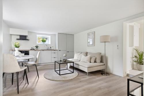 斯塔万格Apartment in Stavanger的白色的客厅配有白色的沙发和桌子