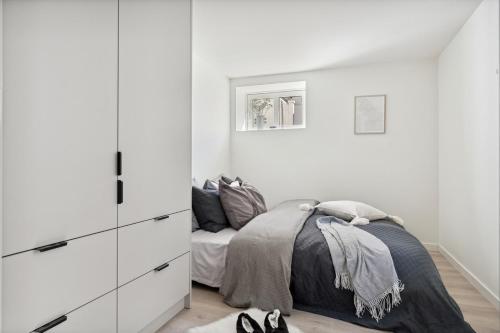斯塔万格Apartment in Stavanger的一间白色卧室,配有一张床和一个梳妆台