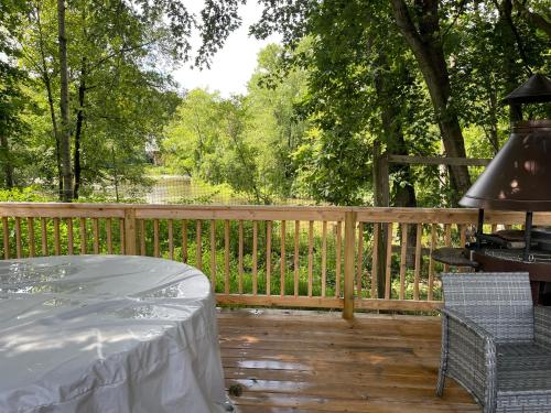 哈德逊Creekside Fantasy Inn的木甲板配有桌子和围栏