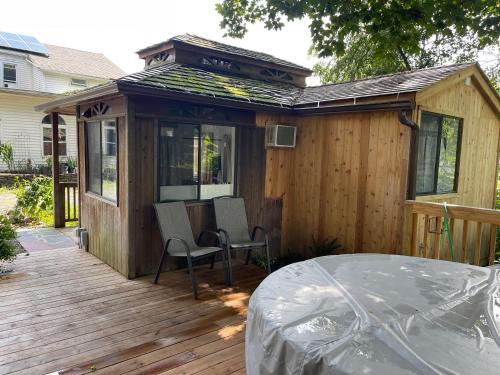 哈德逊Creekside Fantasy Inn的小木屋设有1个带桌椅的甲板