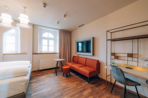 兰茨胡特Hotel Amalia - Boutique Hotel的酒店客房配有床、沙发和桌子。