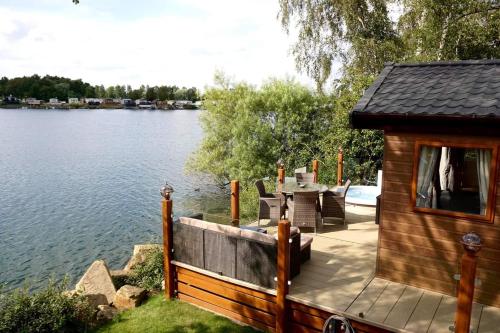 塔特舍尔Fable Lodge Tattershall Lakes - luxury lakeside lodge with hot tub的湖畔小屋,配有桌椅